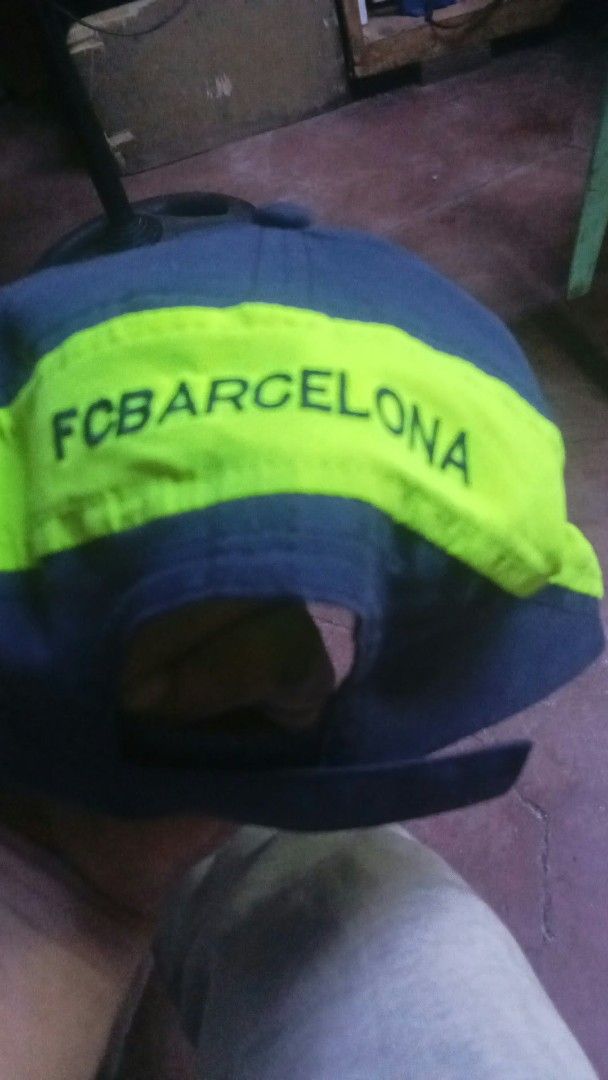FC Barcelona Official Merchandise Baseball Cap (Category: Caps & Hats) located in Manila. Submitted by josephlim13 (Listing ID 1465428503, Image 2). Description: - Official FC Barcelona merchandise ('Producte Oficial' tag) - Dark grey colorway with striking neon yellow trim - Embroidered club crest on the front and '1899' detail on the brim - 'FC Barcelona' text printed across the adjustable back strap - Clean fabric showing only normal signs of 