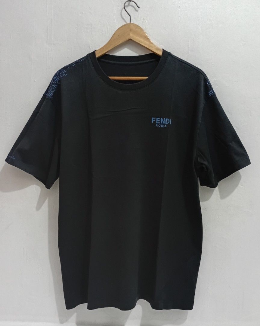 FENDI ROMA MENS TSHIRT (Category: Luxury Apparel) located in Navotas City. Submitted by ms.soulana (Listing ID 1465394807, Image 1). Description: PREOWNED LIGHTLY USED Fendi Roma MENS BLACK TSHIRT - Color: Black with blue logo - Size: Large -XL - Material: 100% cotton - Design: Blue Fendi Roma logo on front chest, repeated down sleeves, and printed on upper back collar - Fit: Standard short sleeve crewneck cut -Likenew ColorRate but have flaws ,o