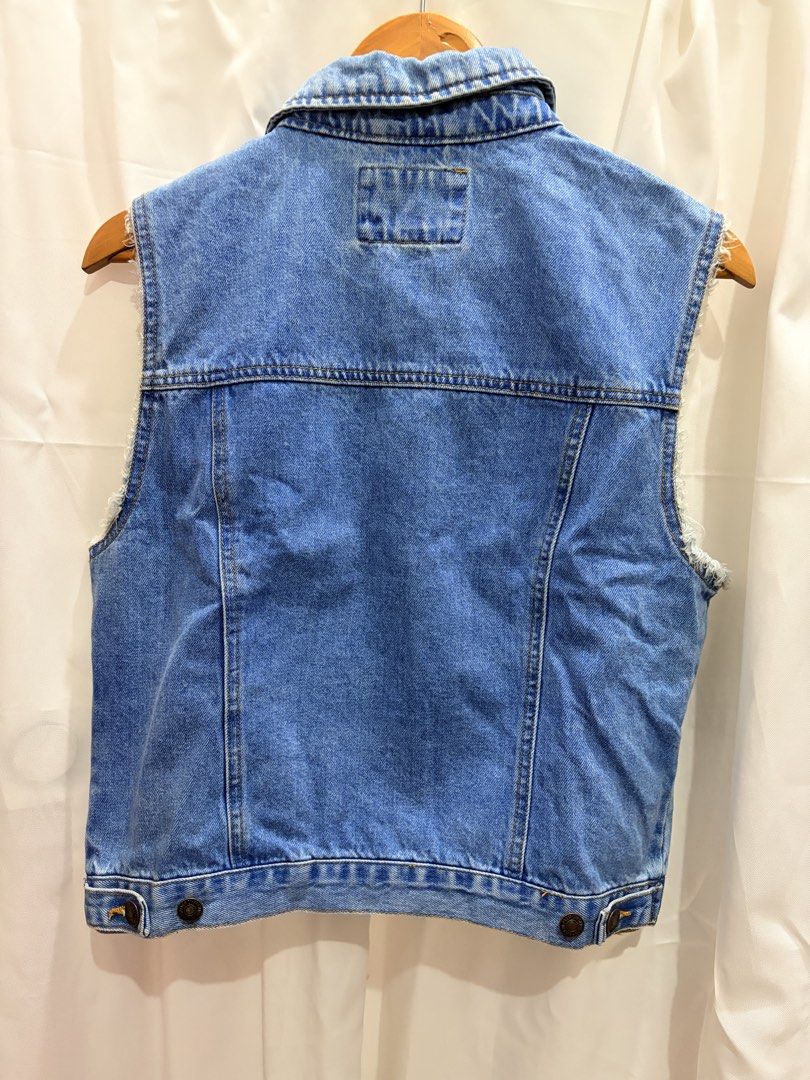 Forever 21 Blue Denim Vest Raw Edge Size M (Category: Sleeveless) located in General Trias. Submitted by hayami.clo (Listing ID 1465386375, Image 2). Description: - Brand: Forever 21 - Size: Medium (tag attached) - Color: Medium wash blue - Design: Classic collar, button-down front with metal buttons - Details: Raw frayed armholes, chest flap pockets, and side welt pockets - Condition: Brand new with tags - Style: Great layering piece for casual 
