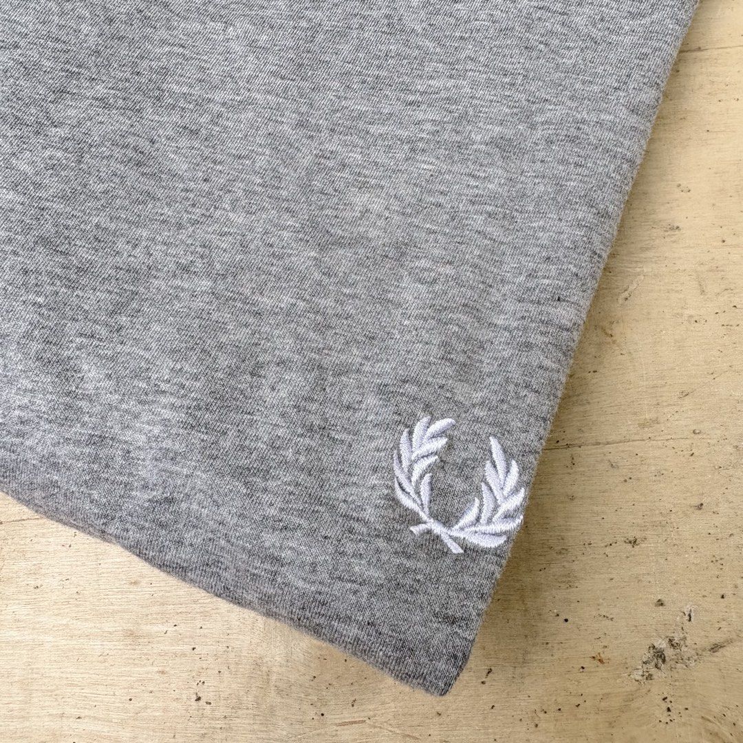 Fred Perry grey t-shirt size M (Category: Tshirts & Polo Shirts ) located in Tagum. Submitted by johntams_ (Listing ID 1465481145, Image 3). Description: - Brand: Fred Perry - Color: Heather Grey - Size: Medium - Fit: Classic fit, short sleeves - Material: Soft cotton blend - Details: Embroidered white laurel wreath logo near hem, black brand label inside collar - Condition/Style: Clean basic tee, perfect for daily wear.