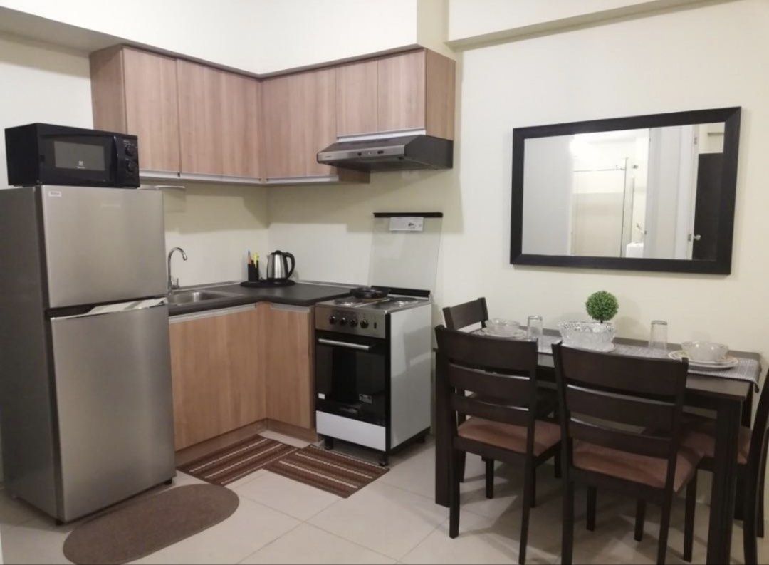 Fully Furnished Studio Condominium Unit With Complete Appliances (Category: Apartments & Condos) located in Bacoor. Submitted by honeybunsshoppe (Listing ID 1465438305, Image 2). Description: - Fully furnished studio layout, move-in ready - Sleeping area: Double bed with pillows & wardrobe closet with mirror doors - Living area: Sofabed, flat screen TV on media console - Dining area: Table with four chairs - Kitchen: Built-in cabinets, refrigerat