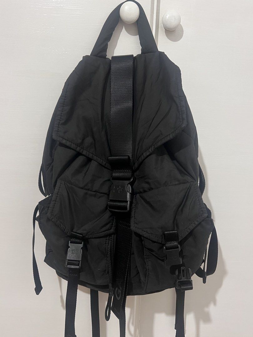 GANNI Recycled Tech Backpack (Category: Backpacks) located in Antipolo. Submitted by minimalistsells (Listing ID 1465540648, Image 3). Description: - Brand: GANNI - Color: Solid Black - Material: Durable nylon with utilitarian hardware - Design: Big center strap with bold branding, minimalist style - Storage: Front pockets with secure buckle closures, great everyday size - Comfort: Top handle and adjustable shoulder straps - Condition: Clean, exc