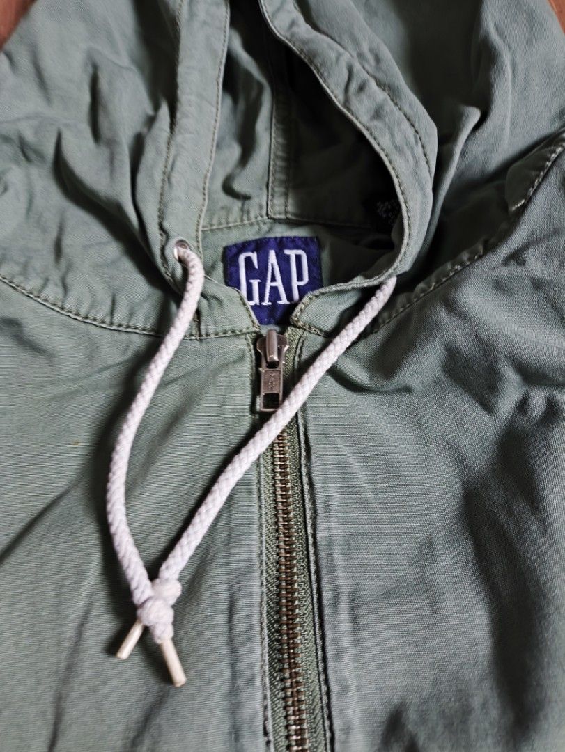 Gap Green Hooded Anorak Jacket Size L (Category: Coats, Jackets and Outerwear) located in Manila. Submitted by phillip.morris (Listing ID 1465396608, Image 3). Description: - Brand: Gap - Item: Green Cotton Anorak Jacket - Size: Large (25" x 27") - Closure: Half-zip front - Details: Drawstring hood and hem with white drawstrings intact, button cuffs, contrast yellow inner hood lining - Graphic: Stenciled N.W. C-46 text graphic near the front pock