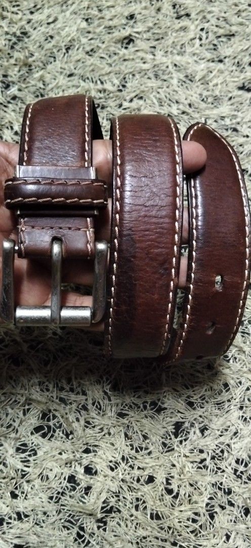 Gerry Cosby pure solid Brown Leather Belt (Category: Belts) located in Paranaque City. Submitted by michael-08 (Listing ID 1465390785, Image 1). Description: - Brand/Style: Gerry Cosby brown leather belt - Details: Contrast stitching with silver-tone metal buckle hardware - Material: Genuine leather strap showing natural texture and wear patterns - Condition: Sturdy construction, ready to wear - Fit: Multiple punched holes for adjustable sizing P