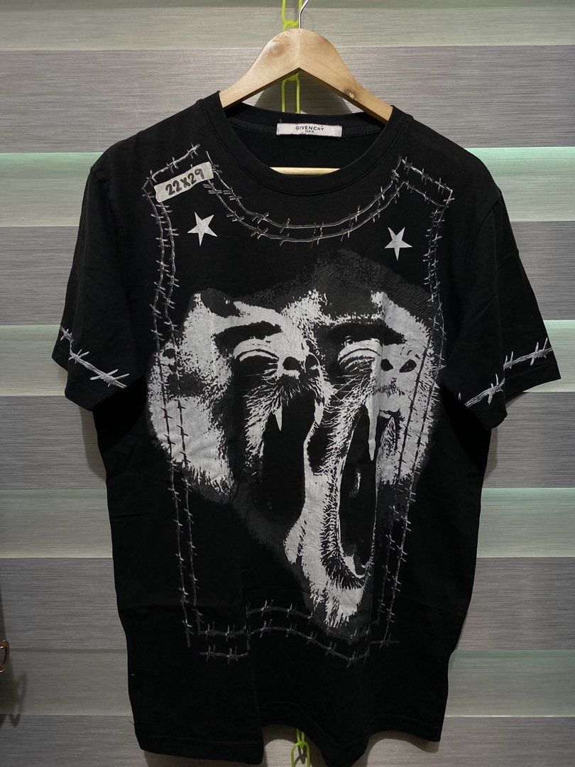Givenchy Paris Black Graphic Tee 22x29 (Category: Shirts) located in Butuan. Submitted by nielben13 (Listing ID 1465412378, Image 1). Description: - Brand: Givenchy Paris - Color: Solid black - Design: Bold front graphic with screaming monkey faces, stars, and barbed wire - Fit: Classic crew neck with short sleeves - Material: Premium cotton - Size: Tag reads 22x29 - Condition: Clean, well-maintained piece with great detailing.