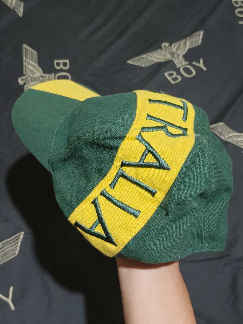 Green and Yellow Australia Cap (Category: Caps & Hats) located in Cagayan de Oro. Submitted by epictiger_2a3d62 (Listing ID 1465412496, Image 2). Description: - Green fabric base with a striking yellow diagonal stripe - Large embroidered 'AUSTRALIA' text wrapping across the crown and brim - Detailed stitched green lettering for a premium look - Casual everyday headwear style - Comfortable fit -Need wash.