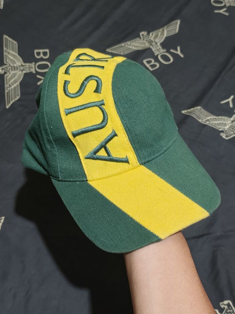 Green and Yellow Australia Cap (Category: Caps & Hats) located in Cagayan de Oro. Submitted by epictiger_2a3d62 (Listing ID 1465412496, Image 1). Description: - Green fabric base with a striking yellow diagonal stripe - Large embroidered 'AUSTRALIA' text wrapping across the crown and brim - Detailed stitched green lettering for a premium look - Casual everyday headwear style - Comfortable fit -Need wash.