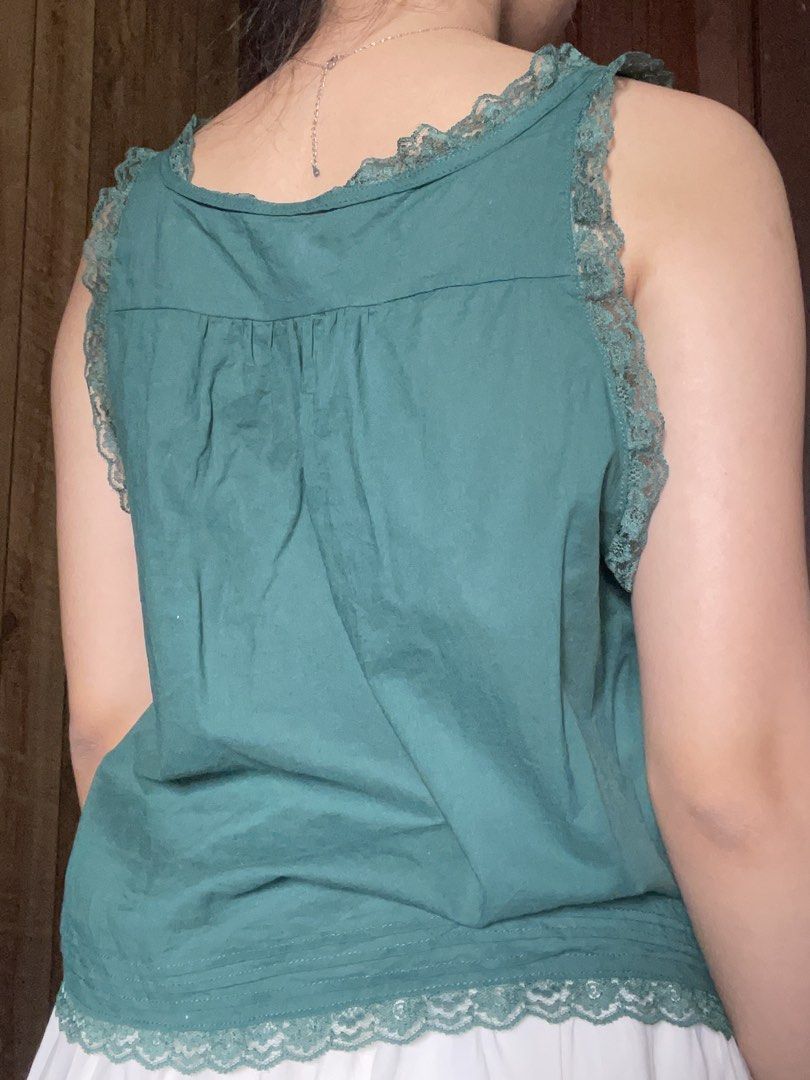 Green Lace Trim Button Down Tank Top (Category: Sleeveless) located in Antipolo. Submitted by jazzminex (Listing ID 1465532206, Image 2). Description: - Color: Green - Material: Soft, lightweight, and breathable cotton - Design: Sleeveless with intricate floral lace trim on the front placket, shoulders, and hem - Details: Small white front buttons and gathered pleats at the back yoke for a relaxed, flowy fit - Style: Casual vintage vibe, easily p