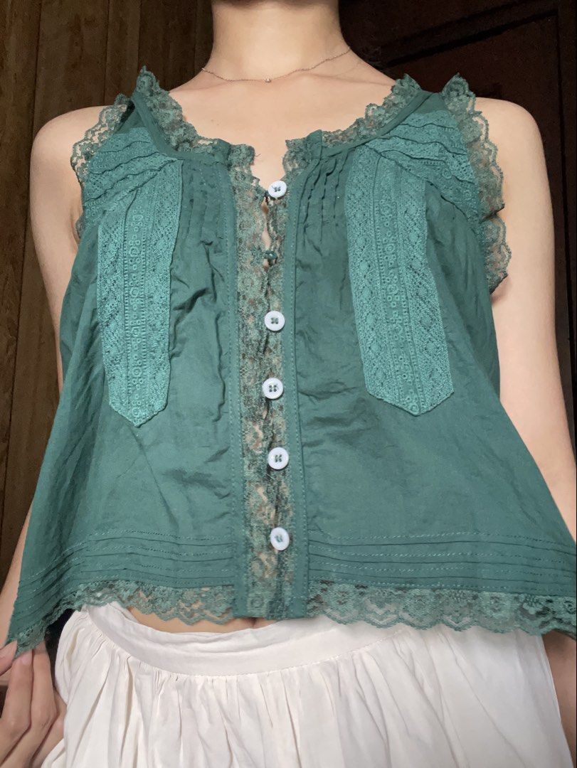 Green Lace Trim Button Down Tank Top (Category: Sleeveless) located in Antipolo. Submitted by jazzminex (Listing ID 1465532206, Image 1). Description: - Color: Green - Material: Soft, lightweight, and breathable cotton - Design: Sleeveless with intricate floral lace trim on the front placket, shoulders, and hem - Details: Small white front buttons and gathered pleats at the back yoke for a relaxed, flowy fit - Style: Casual vintage vibe, easily p