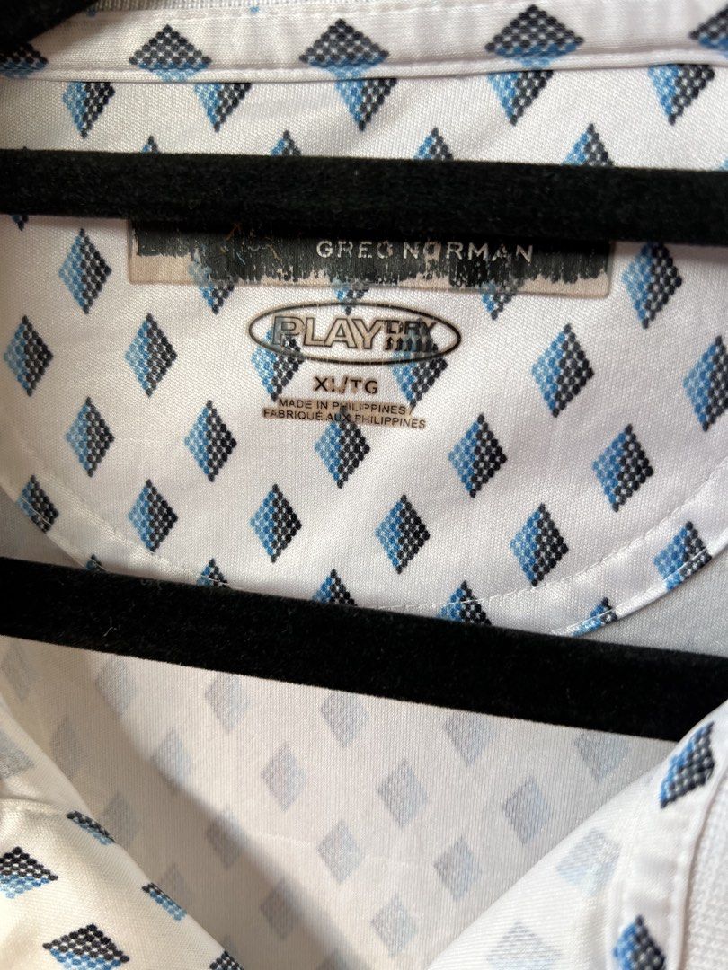 Greg Norman PlayDry Diamond Pattern Golf Polo XL (Category: Tshirts & Polo Shirts ) located in Taytay. Submitted by cside1900 (Listing ID 1465386652, Image 3). Description: - Brand: Greg Norman - Style: Golf polo shirt with blue and black diamond geometric pattern - Size: XL - Color: White - Material/Tech: PlayDry moisture-wicking fabric for ultimate comfort on the course - Details: Classic collar, two-button placket, and signature embroidered sh