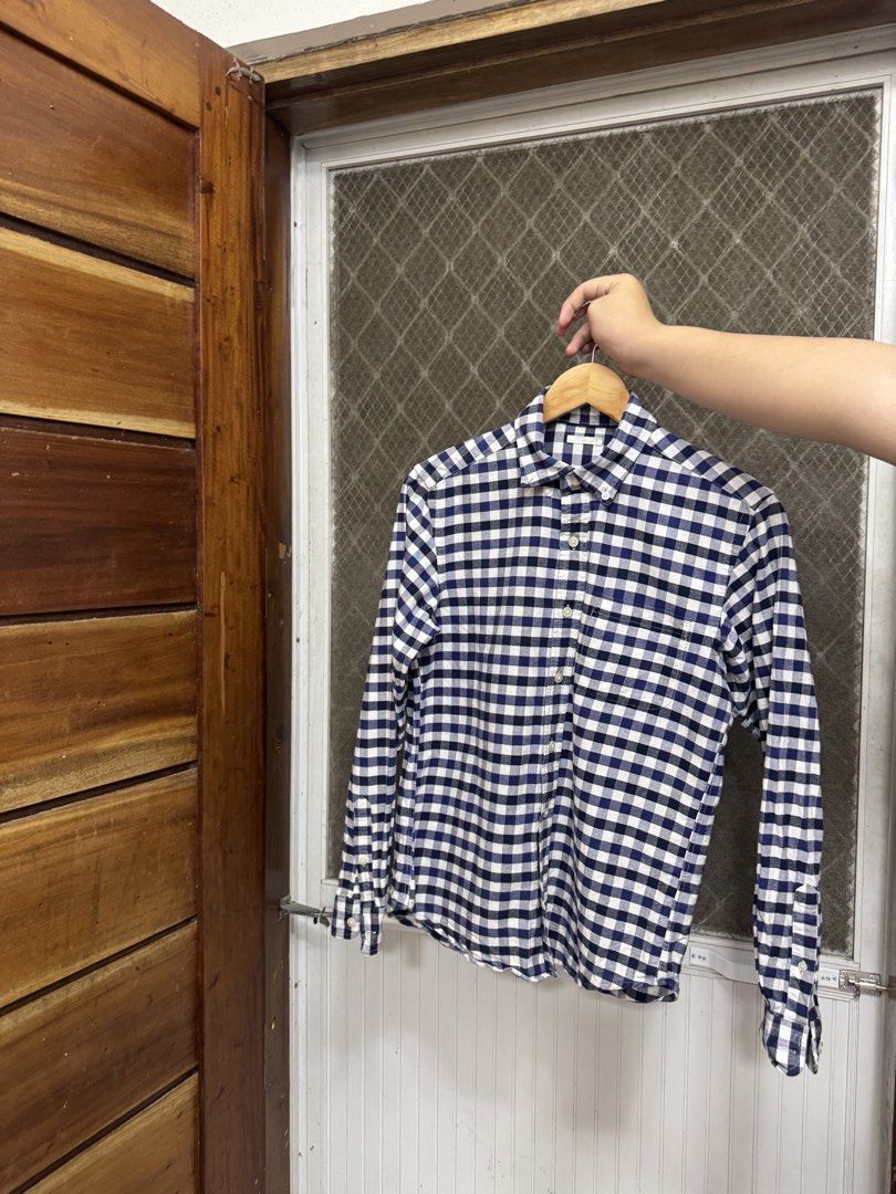 GU Navy and white checkered long sleeve button-down shirt (Category: Tshirts & Polo Shirts ) located in Cavite. Submitted by yakultjeni85475 (Listing ID 1465570268, Image 2). Description: - Color & Pattern: Navy and white checkered/plaid - Design: Long sleeve, front button closure, standard collar, and chest pocket - Condition: Well-maintained fabric with a clean overall look - Versatility: Great for daily wear, office settings, or weekend outing