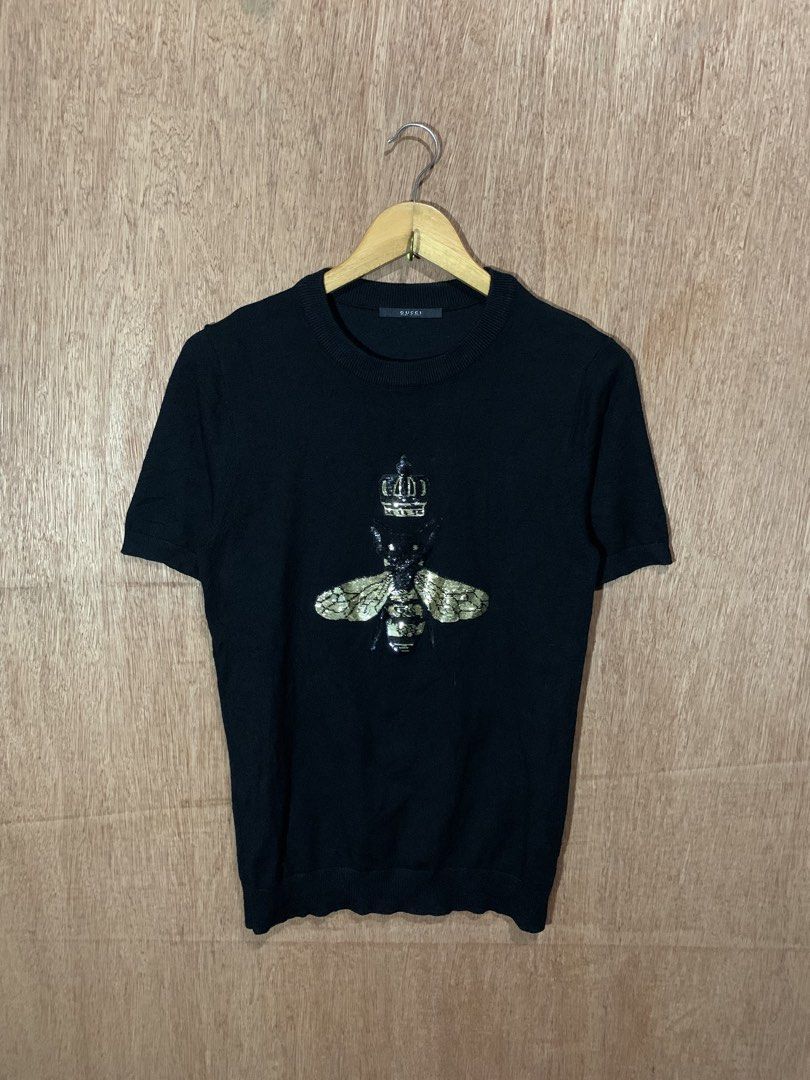 Gucci Black Bee Crown Sweater (Category: Networking) located in Tacurong. Submitted by ljsthrift (Listing ID 1465463104, Image 1). Description: - Gucci short-sleeve knit sweater in timeless black - 100% premium cotton fabric, crafted in Italy - Features a signature embroidered bee and crown design on the chest - Classic crew neck with clean ribbed trim - Original Gucci neck tag and care labels attached - Excellent, clean condition.