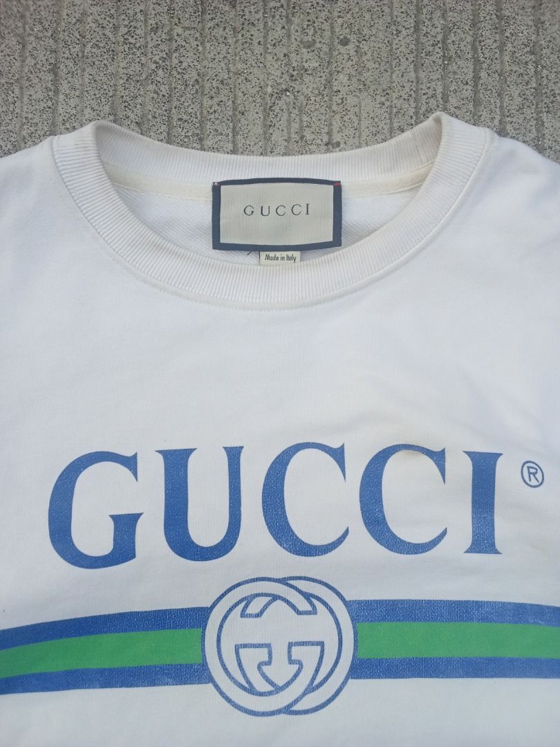 Gucci White Logo Sweatshirt (Category: Coats, Jackets and Outerwear) located in Caloocan City. Submitted by mysticdog-6a6b (Listing ID 1465447398, Image 2). Description: - Authentic Gucci sweatshirt in classic white - Features iconic blue/green logo graphic with Interlocking G emblem - Size: Medium (M) - Material: Comfortable cotton blend fleece - Details: Ribbed collar, cuffs, and hem - Origin: Made in Italy - Condition: Excellent.