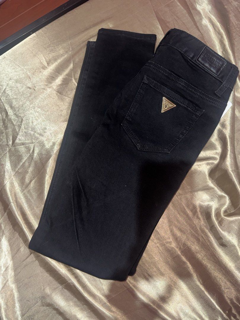 Guess Black Skinny Jeans (Category: Jeans) located in Binan City. Submitted by notsofritz (Listing ID 1465414874, Image 1). Description: - Brand: Guess - Style: Skinny jeans, mid-rise - Size 26 - Color/Wash: Dark wash black denim - Material: Comfortable fabric with a bit of stretch - Details: Classic pocket layout with signature small gold triangle logo badge on back pocket - Condition: Great everyday pair.