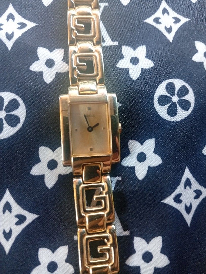 Guess Gold Tone Rectangular Link Bracelet Watch (Category: Women's Watches) located in Puerto Princesa. Submitted by cantfwdricko (Listing ID 1465384258, Image 2). Description: - Brand: Guess - Style: Classic retro gold-tone wristwatch - Dial: Rectangular face - Bracelet: Unique cutout links shaped like the letter 'G' - Closure: Clasp engraved with the Guess logo - Movement: Quartz (battery-operated) - Details: Case back stamped with model inform