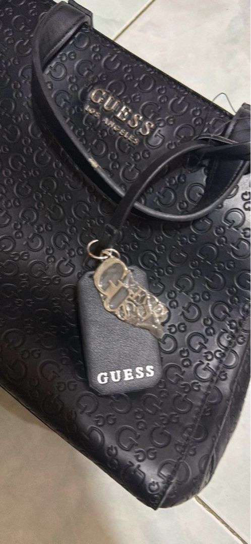Guess Los Angeles Black Monogram Handbag (Category: Luxury Bags & Wallets) located in Manila. Submitted by foundedandfitted (Listing ID 1465533259, Image 3). Description: - Brand: Guess Los Angeles - Color/Material: Black faux leather with all-over debossed monogram - Hardware & Accents: Metal Guess logo on front and matching hanging logo charm - Handles: Double top handles for easy carrying - Interior: Fabric-lined with a secure central zip comp