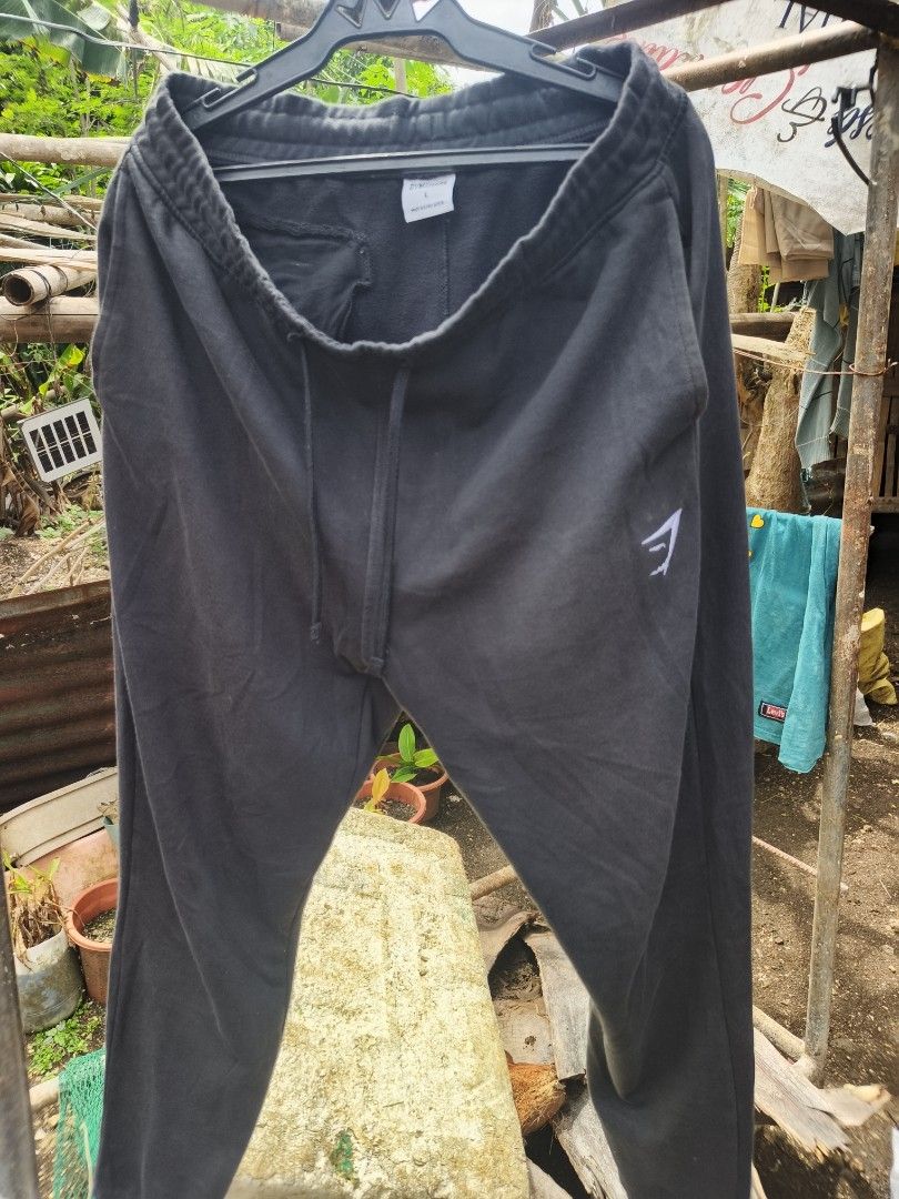 GYMSHARK Joggers (Category: Activewear) located in Manila. Submitted by carlorufo11372 (Listing ID 1465409026, Image 3). Description: Black Gymshark Crest Joggers featuring the brand's signature shark head logo on the upper left leg. Size 34 Lenght 40.