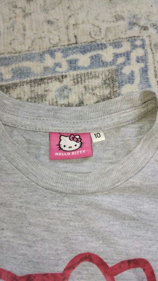 Hello Kitty Grey T-shirt Size 10 (Category: Shirts) located in Manila. Submitted by mightytiger.ba9f66 (Listing ID 1465393945, Image 2). Description: - Item: Grey Kitty Short-Sleeve T-Shirt - Size: 10 (Tag intact) - Material: Lightweight, breathable cotton - Design: Cute pink Kitty graphic and script logo - Style: Round neckline, casual everyday fit - Condition: Excellent / Well-maintained - Shipping: Fast ship-out from a trusted PH seller!.
