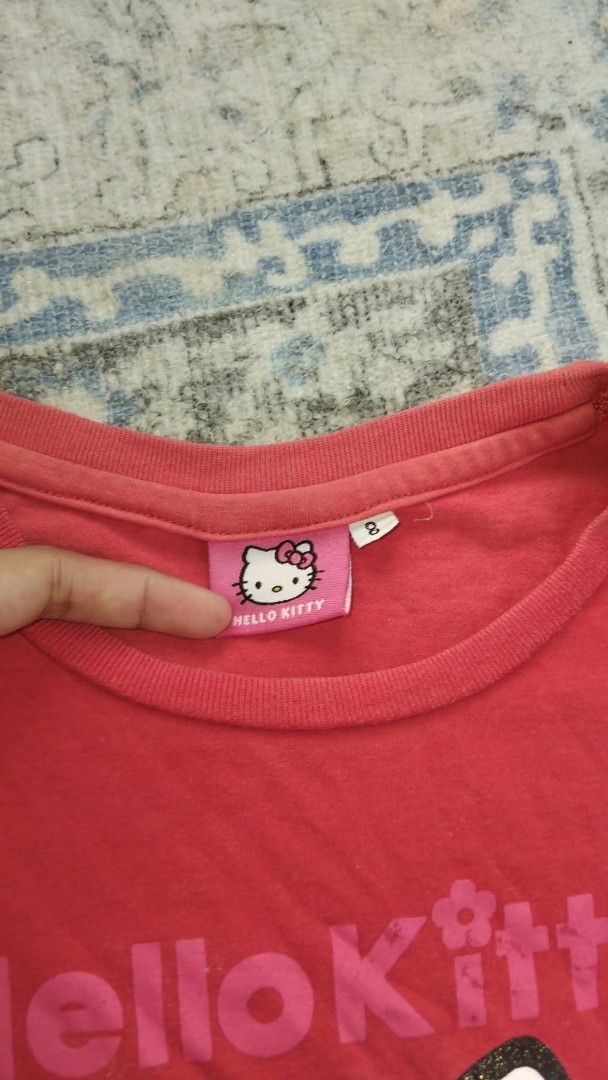 Hello Kitty Sanrio Red Graphic Tee Size 8 (Category: Shirts) located in Manila. Submitted by mightytiger.ba9f66 (Listing ID 1465394317, Image 2). Description: - Size: 8 - Material: Soft 100% cotton for everyday wear - Design: Bright red color with a large Kitty / Sanrio graphic and sparkle glitter details - Features: Cute ruffled short shoulders, classic crew neckline, and original branded pink neck tag - Condition: Excellent, perfect for daily o