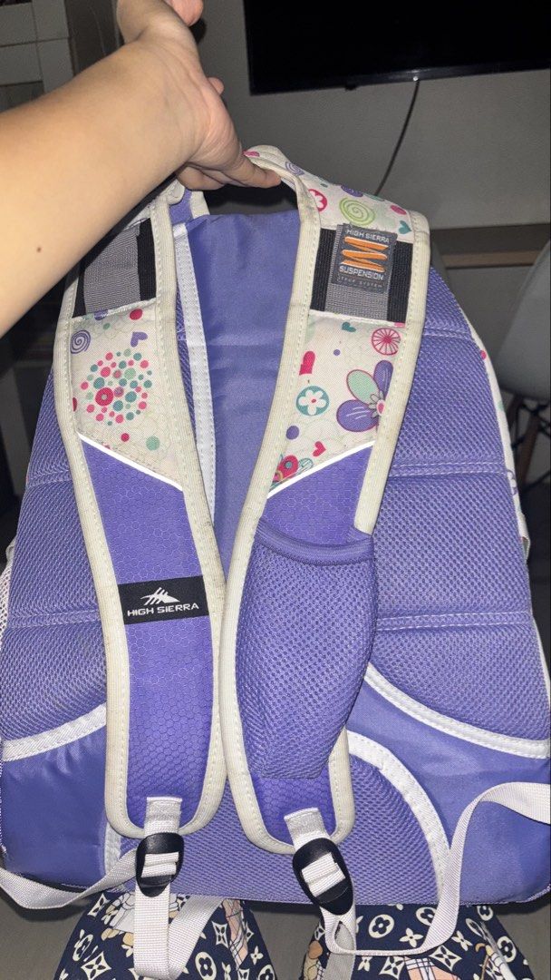 High Sierra Hiking Purple Backpack (Category: Backpacks) located in Manila. Submitted by cheetosjalapeno.f6b498 (Listing ID 1465534525, Image 3). Description: High Sierra backpack with a fun floral pattern against a white and purple design. Includes padded shoulder straps featuring their suspension system for extra comfort. Multiple zippered compartments and front clip attached. Built for school, travel, or everyday use. Shows some light wear alo