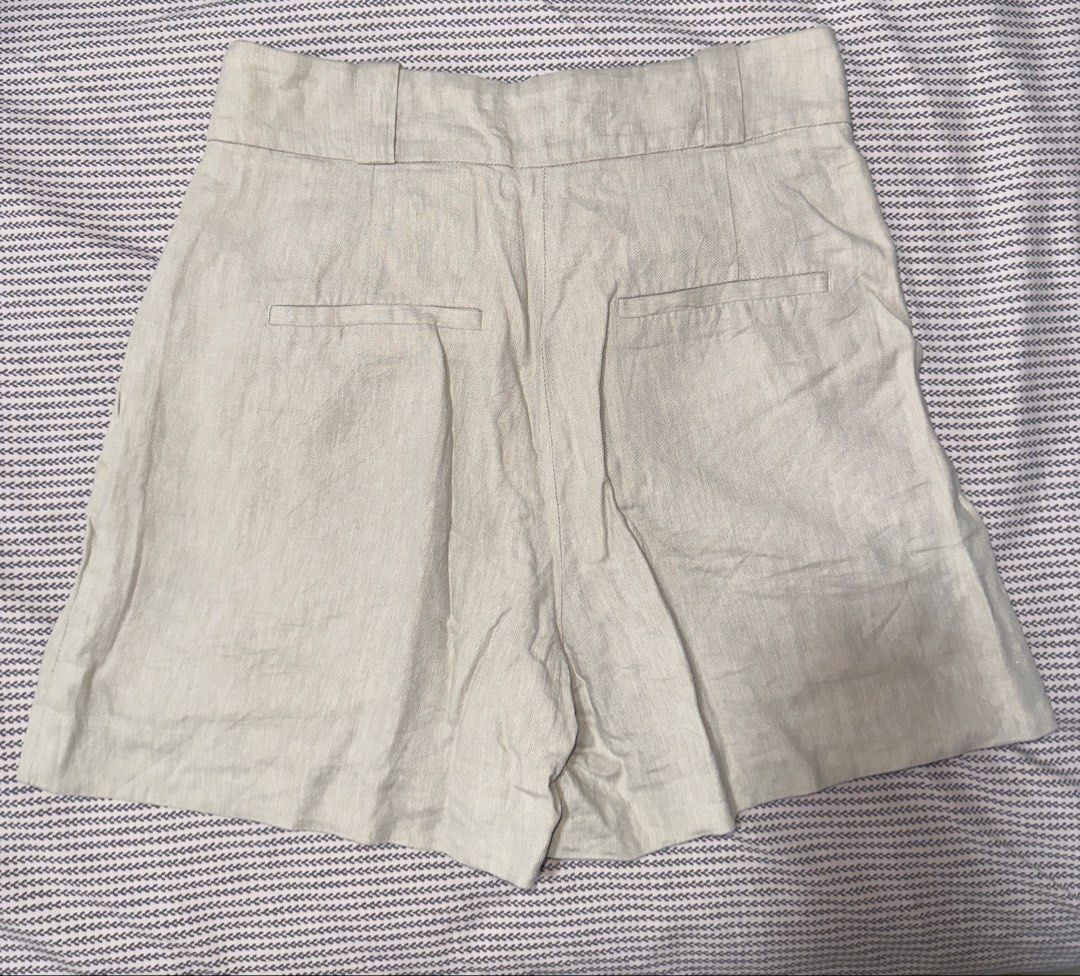 H&M Beige Linen Blend Shorts Size US 4 (Category: Shorts) located in Santa Ana. Submitted by fatikilla (Listing ID 1465432339, Image 3). Description: - Brand: H&M - Size: US 4 / EUR 36 - Color: Classic Beige - Material: Breathable linen blend - Fit: High-waisted with front pleats and belt loops - Details: Zipper fly, button closure, and back welt pockets - Condition: Excellent, clean fabric with no major wear.