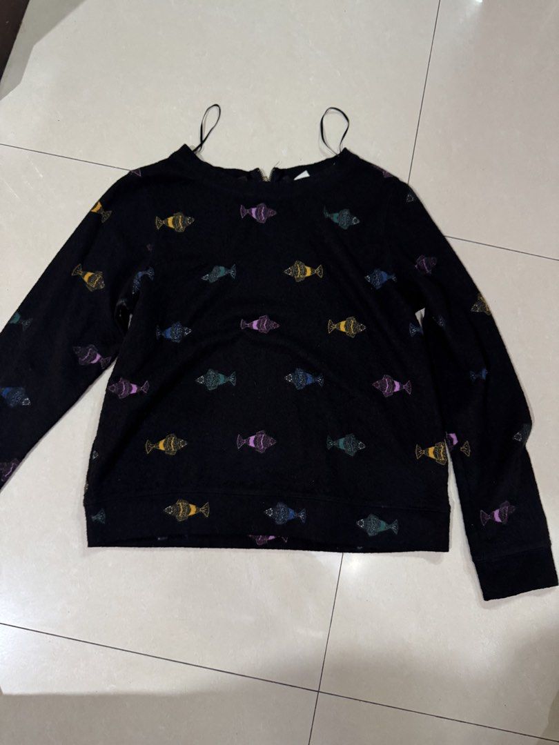 H&M Black Fish Print Sweatshirt (Category: Longsleeves) located in Quezon City. Submitted by sweetlyluxe (Listing ID 1465487100, Image 1). Description: - Brand: H&M - Size: XS but fits S - Color: Black with colorful fish prints (yellow, purple, blue, green) - Material: Soft textured fabric - Features: Gold zipper detail at the back neckline, shoulder strap loops - Style: Simple pull-on long sleeve sweater for winter.