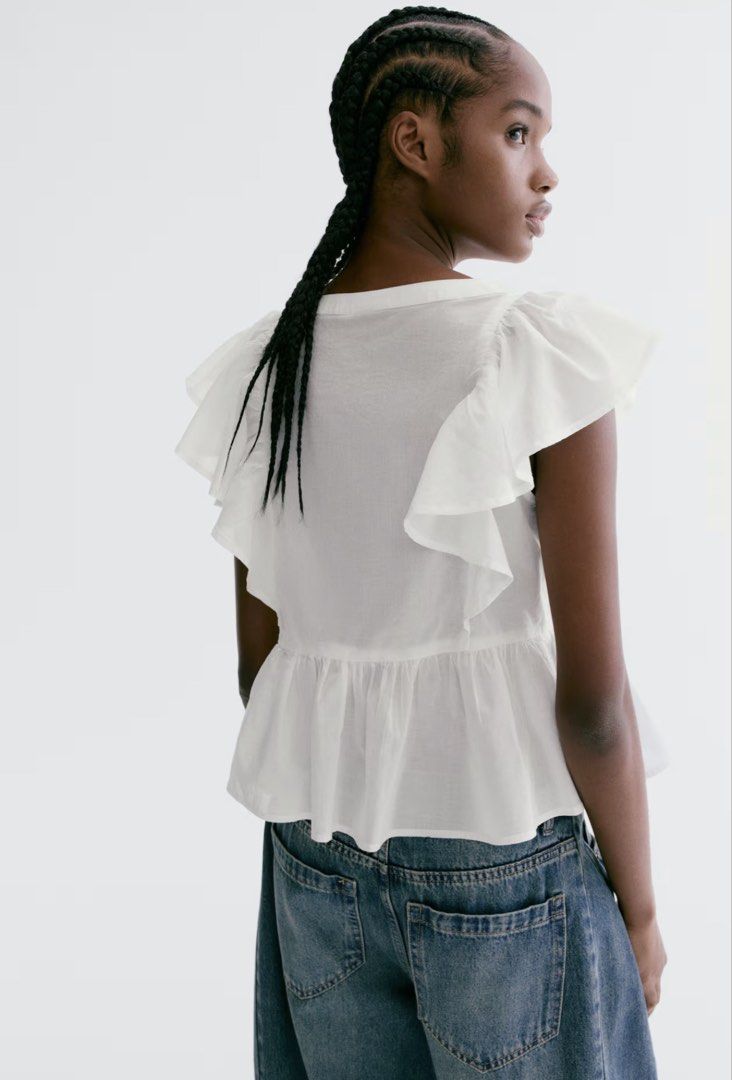 H&M Divided White Ruffle Pleated Blouse Top (Category: Blouses) located in La Paz. Submitted by cldn.co (Listing ID 1465395969, Image 3). Description: - Brand: H&M Divided - Color: White - Material: Lightweight cotton - Design details: Dramatic ruffled cap sleeves, pintuck pleating on the front, and a tiered peplum hem - Neckline: Square neckline - Condition: Clean and ready to wear - Styling tip: Perfect to pair with high-waisted denim jeans or 