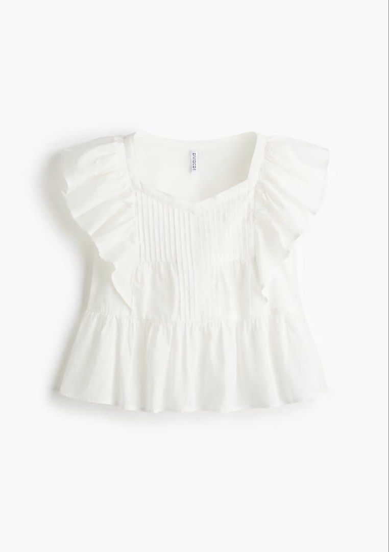 H&M Divided White Ruffle Pleated Blouse Top (Category: Blouses) located in La Paz. Submitted by cldn.co (Listing ID 1465395969, Image 1). Description: - Brand: H&M Divided - Color: White - Material: Lightweight cotton - Design details: Dramatic ruffled cap sleeves, pintuck pleating on the front, and a tiered peplum hem - Neckline: Square neckline - Condition: Clean and ready to wear - Styling tip: Perfect to pair with high-waisted denim jeans or 