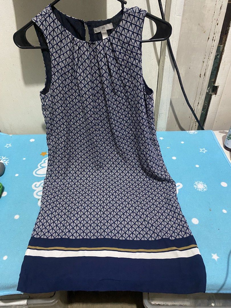 H&M Sleeveless Geometric Pattern Dress Navy Blue (Category: Dresses) located in Manila. Submitted by resi.diaz (Listing ID 1465481815, Image 1). Description: - Brand: H&M - Color: Navy blue with gold and white accents - Design: Geometric fan pattern with striped hem detail - Style: Sleeveless, rounded neckline, keyhole opening with back button closure - Lining: Plain dark blue lining on the reverse side - Material: Lightweight and comfortable - C