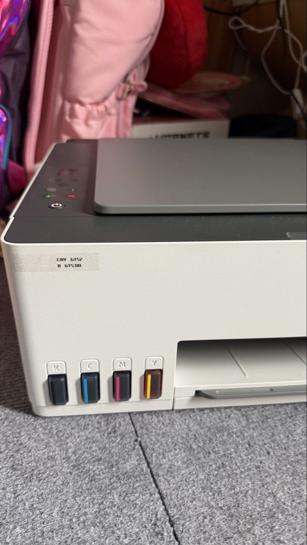 HP Smart Tank 580 All-in-One Printer (Category: Printers, Scanners & Copiers) located in Muntinlupa City. Submitted by nisantos (Listing ID 1465437073, Image 2). Description: HP Smart Tank 580 wireless all-in-one printer. Uses GT52 color and GT53XL black ink tanks visible on the front panel. Compact white and dark grey body design with built-in scanner lid on top. LCD screen shows an E40 error code and warning light currently active. Great tank s