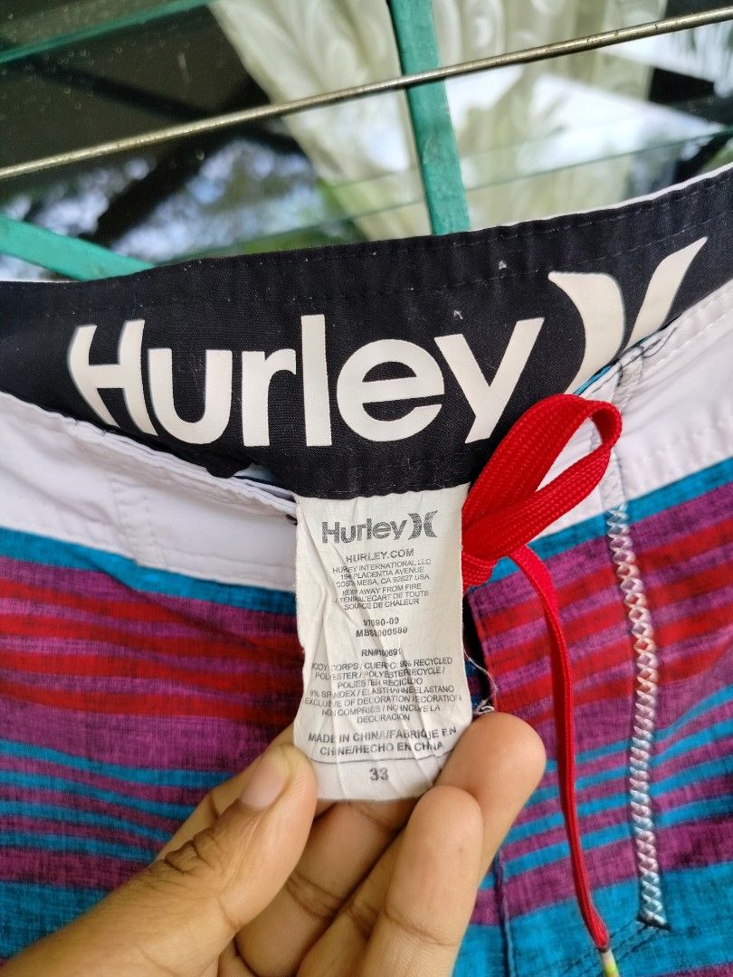 Hurley Striped Board Shorts Men Size 33 (Category: Swim Trunks & Board Shorts) located in Manila. Submitted by gerald_quinto (Listing ID 1465471675, Image 2). Description: - Brand: Hurley - Size: 33 (tag attached) - Design: Colorful horizontal stripes in red, teal, and purple - Features: White waistband with red drawstring closure, white piping with large Hurley text on the left leg, small Hurley icon on the right hem - Storage: Back pocket with 