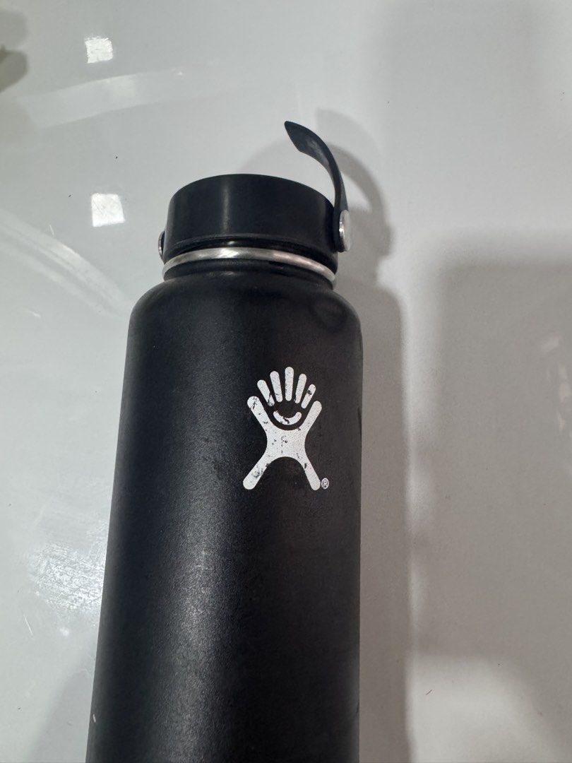 Hydro Flask Black Insulated Water Bottle (Category: Water Bottles & Tumblers) located in Manila. Submitted by decluterthings888 (Listing ID 1465396904, Image 2). Description: - Authentic Hydro Flask water bottle in classic black - Standard wide mouth design for easy cleaning and adding ice - Includes matching black cap and protective blue silicone boot - Keeps drinks cold for hours - Condition note: Visible dents near the top rim and minor scuffs