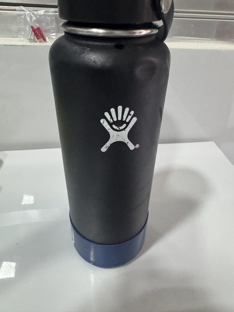 Hydro Flask Black Insulated Water Bottle (Category: Water Bottles & Tumblers) located in Manila. Submitted by decluterthings888 (Listing ID 1465396904, Image 3). Description: - Authentic Hydro Flask water bottle in classic black - Standard wide mouth design for easy cleaning and adding ice - Includes matching black cap and protective blue silicone boot - Keeps drinks cold for hours - Condition note: Visible dents near the top rim and minor scuffs