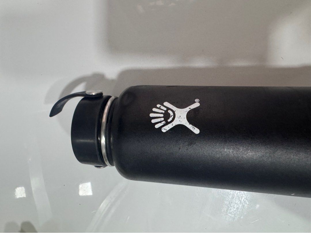 Hydro Flask Water Bottle Black with Blue Boot (Category: Water Bottles & Tumblers) located in Manila. Submitted by decluterthings888 (Listing ID 1465396949, Image 1). Description: - Color: Black with blue silicone boot - Included: Standard black cap with handle - Branding: White Hydro Flask logo on the side - Condition: Normal signs of use, includes visible dents and scratches on the body and logo - 100% authentic and ready for daily use.