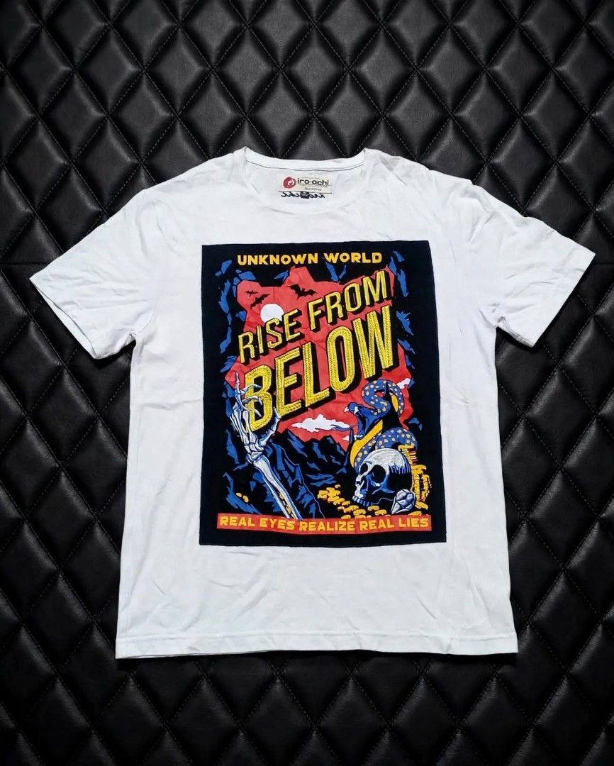 Iro-Ochi 'Rise From Below' Graphic Tee White Size M (Category: Tshirts & Polo Shirts ) located in Aguinaldo. Submitted by ukayandthrift (Listing ID 1465386531, Image 1). Description: - Brand: Iro-Ochi - Color: White - Size: Medium (tagged at inner collar) - Design: Large front graphic with skeleton hand, snake, skull, and 'Rise From Below' text - Details: 'Real Eyes Realize Real Lies' printed along the bottom edge - Fit: Short sleeves, classic cr