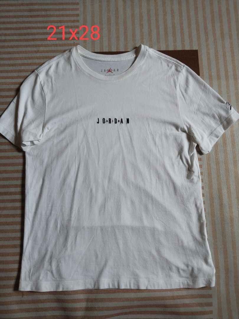 Jordan White T-Shirt Size XL (Category: Tshirts & Polo Shirts ) located in Manila. Submitted by polding25 (Listing ID 1465387175, Image 1). Description: - Brand: Jordan - Color: White with stylized black lettering - Size: XL (Approx. 21" width x 28" length) - Details: Jumpman logo on inner collar and sleeve, Made in China - Condition: Good overall, with a noticeable small pinkish stain near the bottom front hem.