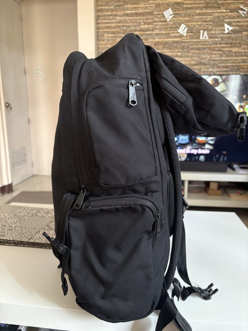 Kangol Black Backpack with Multiple Compartments (Category: Backpacks) located in Manila. Submitted by kakiboyo (Listing ID 1465392869, Image 3). Description: Black Kangol backpack with lots of storage. Front logo patch and side zip pockets. Padded shoulder straps with buckle details. Inside has a laptop sleeve, mesh zipper pocket, and utility slots with name tags. Clean grey interior lining..