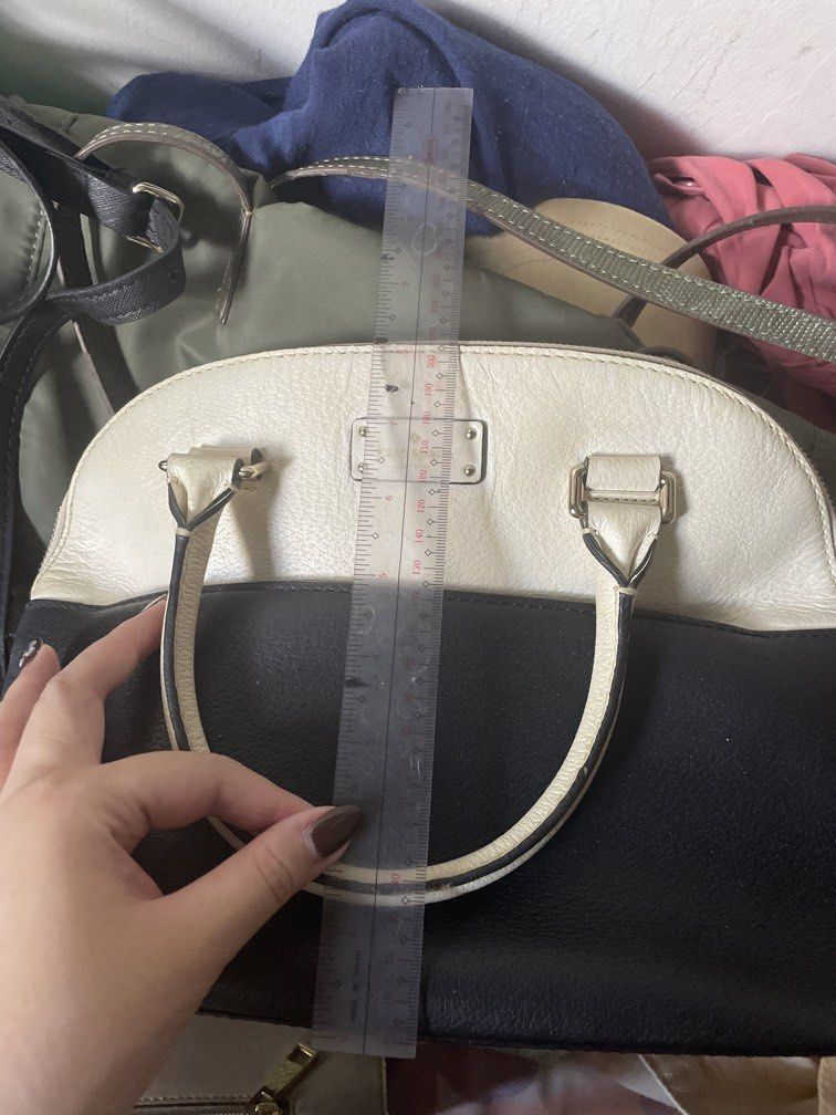 Kate Spade Black and White Dome Handbag ORIGINAL (Category: Tote Bags) located in Arayat. Submitted by mauikabigting (Listing ID 1465480511, Image 3). Description: Kate Spade dome handbag in black and white leather. Gold-tone hardware with the classic metal logo plaque on the front. Double top handles. Zipper closure across the top. Approximate dimensions measure around 21 cm in height and 32 cm in width based on the ruler in photos. Structured e