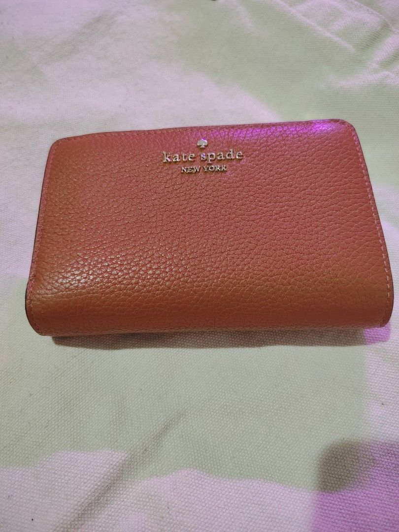 Kate Spade leather wallet (Category: Wallets & Card holders) located in Mandaluyong City. Submitted by declutter_kween (Listing ID 1465524868, Image 2). Description: - Brand: Kate Spade New York - Material: Clean pebbled textured leather - Color: Brown - Closure: Fold-over tab with secure snap - Details: Signature metal front lettering - Size: Compact, fits easily in smaller bags.