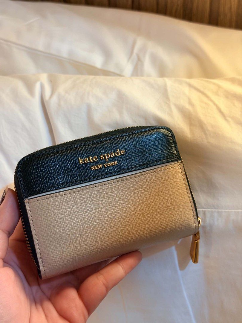 Kate Spade New York Zip Around Wallet (Category: Wallets & Card holders) located in Manila. Submitted by iamsassycl95926 (Listing ID 1465465855, Image 1). Description: - Brand: Kate Spade - Color: Black and Warm Beige - Material: Textured leather with gold-tone hardware - Interior: Multiple card slots, slip pockets, and central zippered coin pouch - Condition: Clean interior and exterior, zipper runs smoothly - Type: Compact zip wallet.