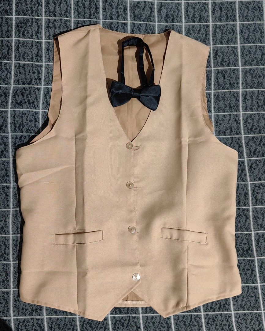 Khaki Vest with Black Bow Tie (Category: Vests) located in Pasay City. Submitted by roe.sell (Listing ID 1465471178, Image 1). Description: - Brand/Item: Lucky MJ khaki formal vest - Size: Tag visible inside near the collar - Includes: Matching black adjustable bow tie - Design: Two-button front closure with piped pocket details - Fit: Adjustable back strap with metal buckle for tailoring - Condition: Clean fabric throughout, ready to wear - Perf