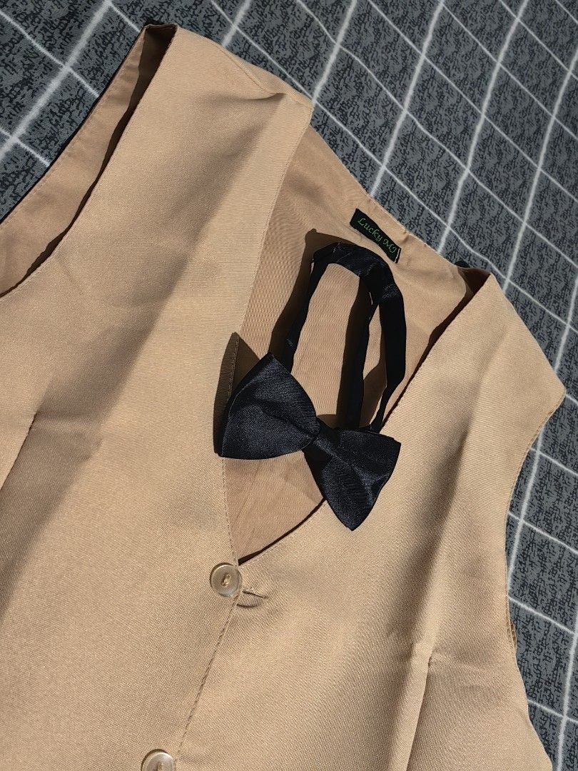 Khaki Vest with Black Bow Tie (Category: Vests) located in Pasay City. Submitted by roe.sell (Listing ID 1465471178, Image 2). Description: - Brand/Item: Lucky MJ khaki formal vest - Size: Tag visible inside near the collar - Includes: Matching black adjustable bow tie - Design: Two-button front closure with piped pocket details - Fit: Adjustable back strap with metal buckle for tailoring - Condition: Clean fabric throughout, ready to wear - Perf