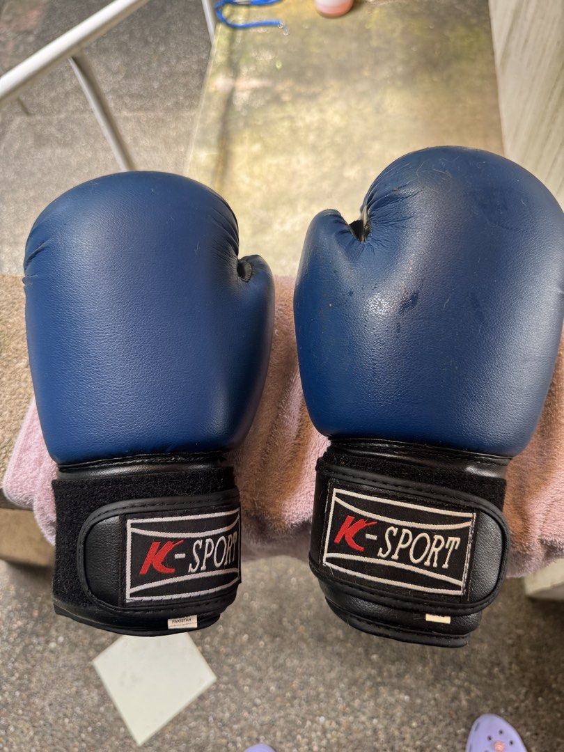 K-Sport Blue Boxing Gloves (Category: Combat Sports) located in Cebu City. Submitted by kdlsstuff (Listing ID 1465424136, Image 1). Description: - Brand: K-Sport - Item: Pair of blue boxing gloves - Features: Black wrist wraps with secure velcro closure, white piped border on logo patches - Condition: Minor scuffs on the right glove surface from previous training sessions - Performance: Padding feels firm and supportive around the knuckles.