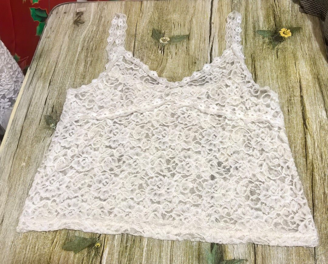 Lace Floral Tank Top (Category: Sleeveless) located in Mexico. Submitted by hele_blushandthrift (Listing ID 1465501349, Image 3). Description: Style: Sleeveless lace camisole / tank top Color: Off-white / White Material: Soft crochet lace with floral pattern, lined inside (not super sheer) Neckline: V-neck with scalloped lace trim Strap: Wide lace straps with floral embroidery detail Fit: Relaxed fit, slightly cropped - perfect as inner or on its