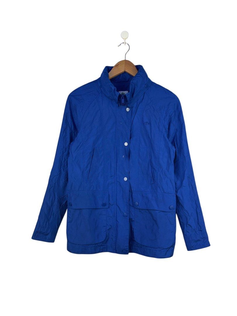 Lacoste Blue Hooded Windbreaker Jacket Size 34 (Category: Coats, Jackets and Outerwear) located in Caloocan City. Submitted by mzcollection_349 (Listing ID 1465403333, Image 1). Description: - Brand: Lacoste - Color: Royal blue with blue & white striped lining accents - Size: 34 - Design: Full zip front with snap-button storm flap, high neck collar with drawstrings - Details: Classic tonal embroidered crocodile logo on the chest, functional pocke
