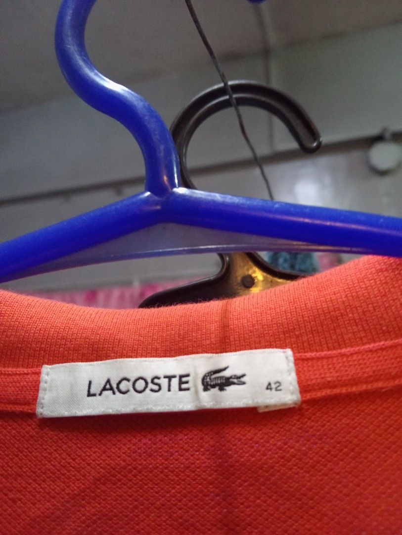 Lacoste Orange Polo Shirt Size 42 (Category: Tshirts & Polo Shirts ) located in Marikina City. Submitted by cosmiccrystal.571e7e (Listing ID 1465417921, Image 2). Description: - Brand: Lacoste - Color: Vibrant bright orange - Material: 100% classic pique knit cotton - Size: 42 - Features: Short sleeves, classic button placket, signature embroidered crocodile logo on the chest - Condition: Excellent pre-loved condition, standard care instructions 