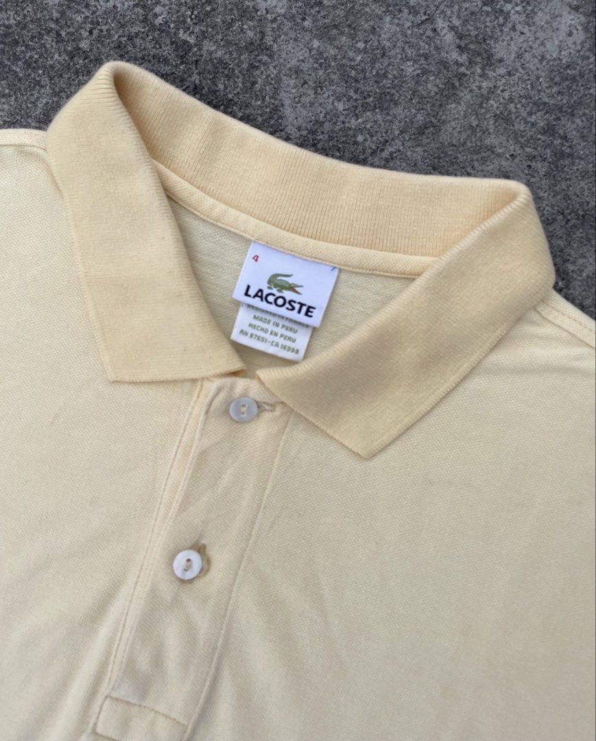 Lacoste Yellow Polo Shirt Size 4 (Category: Tshirts & Polo Shirts ) located in Manila. Submitted by ajzeemlimbamidzid (Listing ID 1465512323, Image 3). Description: - Brand: Lacoste - Color: Soft pastel yellow - Size: 4 (Designed in France, Made in Peru) - Material: Classic breathable pique knit texture - Details: Two-button placket with pearlescent buttons, ribbed collar and sleeve cuffs - Logo: Iconic embroidered green crocodile on the chest - 