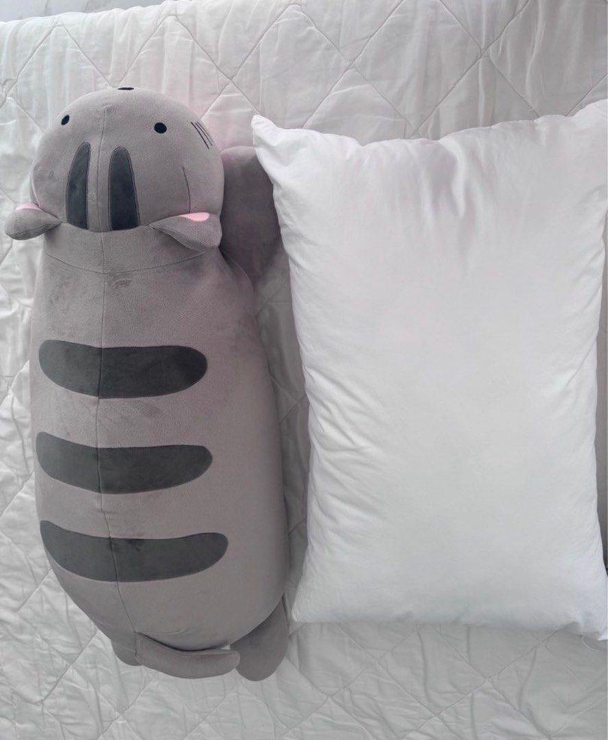 Large grey striped cat plush body pillow (Category: Bedding & Towels) located in Manila. Submitted by decluterthings888 (Listing ID 1465397652, Image 1). Description: - Super soft giant cat pillow in grey with dark grey stripes - Features cute pink inner ears and black embroidered eyes - Extra-long body, perfect for hugging while sleeping or lounging - Clean fabric with zero stains or damage - Smoke-free and well-maintained condition.
