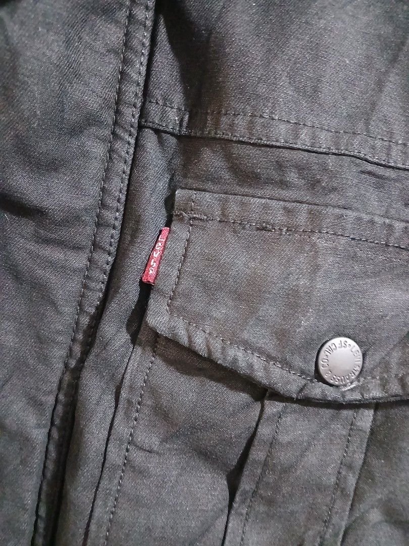 Levi's Black Casual Button-Up Jacket Size M (Category: Coats, Jackets and Outerwear) located in Taguig. Submitted by thriftnilhan (Listing ID 1465404831, Image 3). Description: - Brand: Levi's - Color: Black - Size: Medium (M) - Closure: Snap buttons on front and cuffs - Pockets: Two chest pockets with snap buttons - Details: Signature red Levi's tab on left pocket, classic collar.
