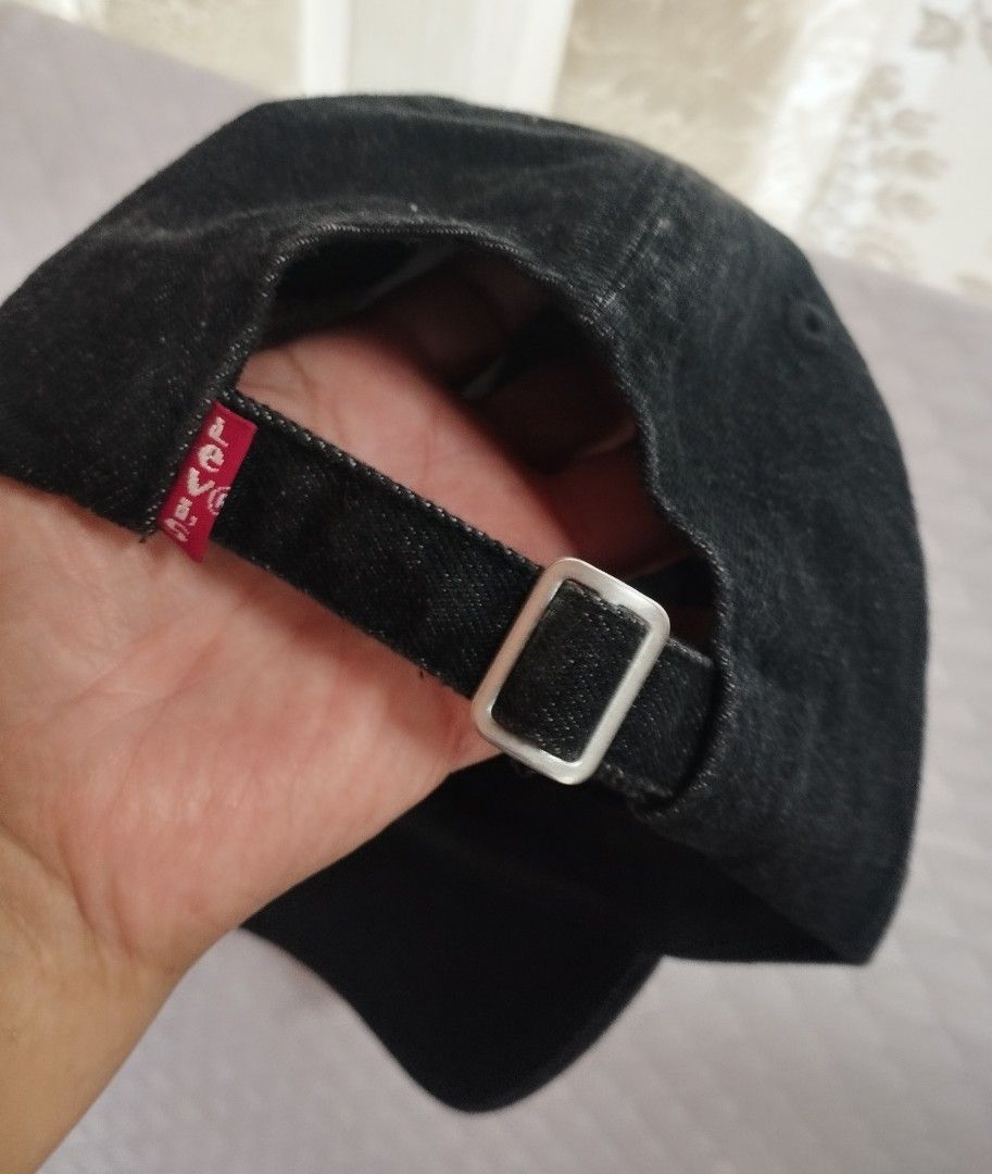 Levi's Black Denim Baseball Cap (Category: Caps & Hats) located in Baguio. Submitted by katgon2016 (Listing ID 1465446101, Image 3). Description: - Brand: Levi's - Color: Classic black denim - Material: 100% premium cotton - Design: Embroidered white Levi's logo on front - Details: Adjustable strap back with silver metal slider and iconic red Levi's tab - Fit: Standard one size fits most - Condition: Clean inside lining with original interior tag